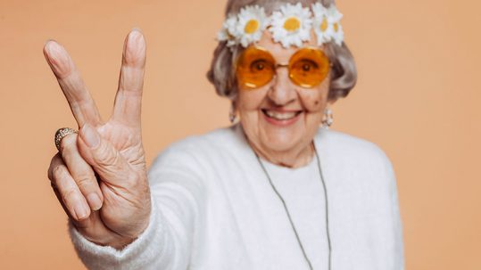 Senyora de 80 años haciendo el simbolo de victoria con los dos dedos