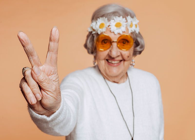 Señora de 80 años haciendo el simbolo de victoria con los dos dedos