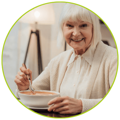 Mujer mayor sentada en la mesa a punto de comer